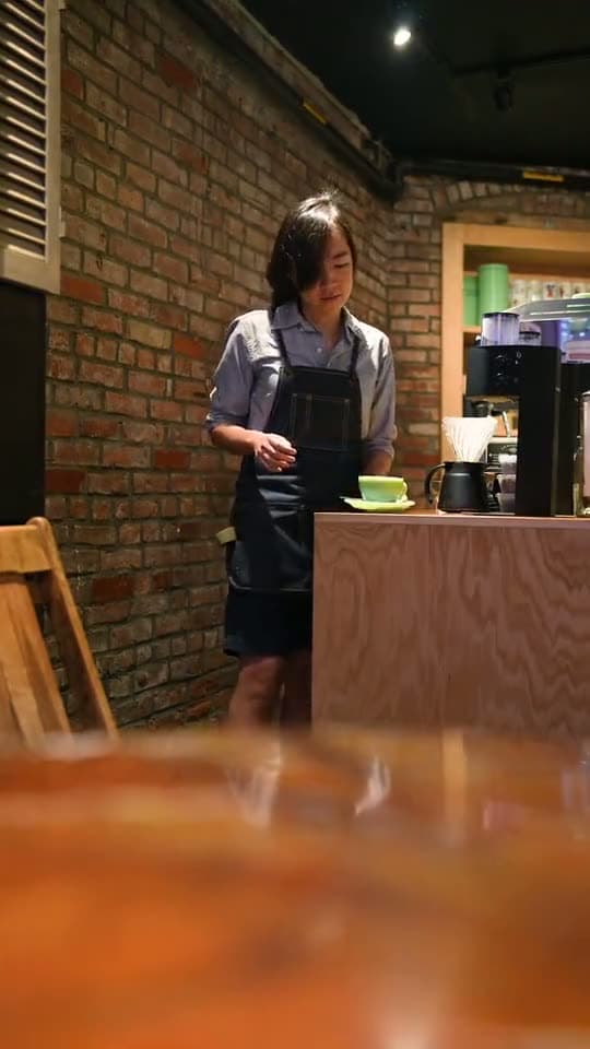 A barista serving a cup of coffee, the background of a cafés and coffee shops sign-in page