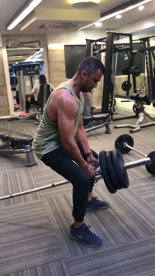 Someone lifting weights in a gym, the background of a gyms and studios sign-in page