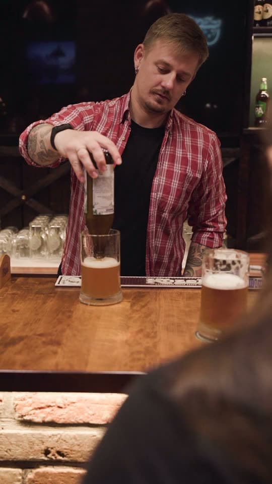 A bartender pouring a drink, the background of a pubs and bars sign-in page