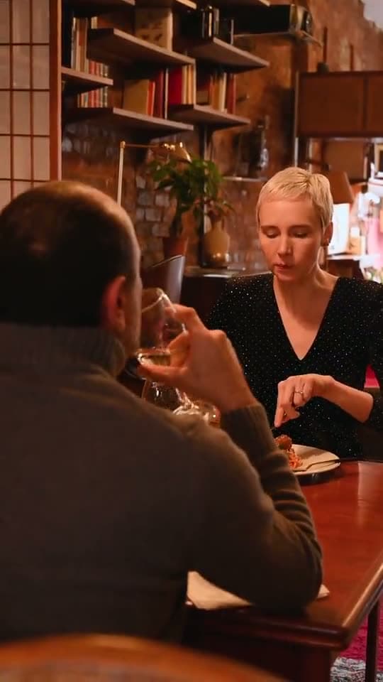Two people talking over a meal, the background of a restaurants sign-in page